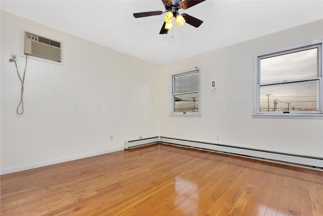 empty room featuring ceiling fan, a healthy amount of sunlight, light wood-type flooring, and an AC wall unit