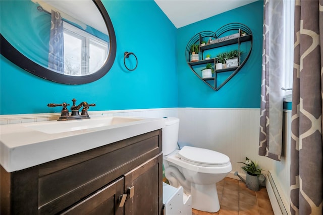 bathroom with tile patterned flooring, a baseboard heating unit, lofted ceiling, toilet, and vanity