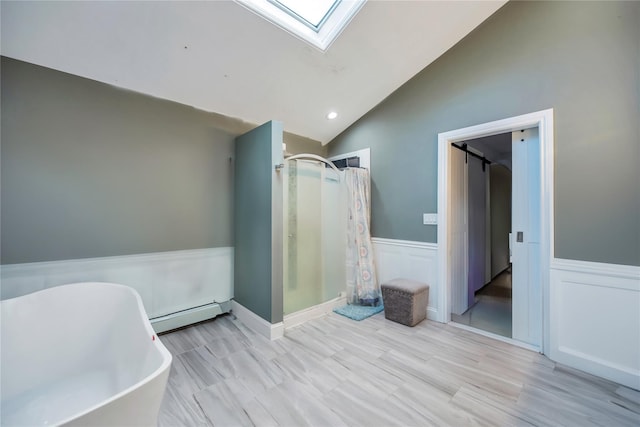 bathroom with vaulted ceiling with skylight, independent shower and bath, and a baseboard heating unit