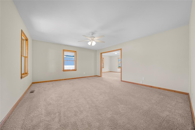 carpeted spare room featuring ceiling fan