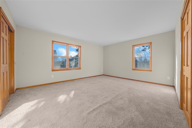 unfurnished bedroom with a closet, light carpet, and multiple windows