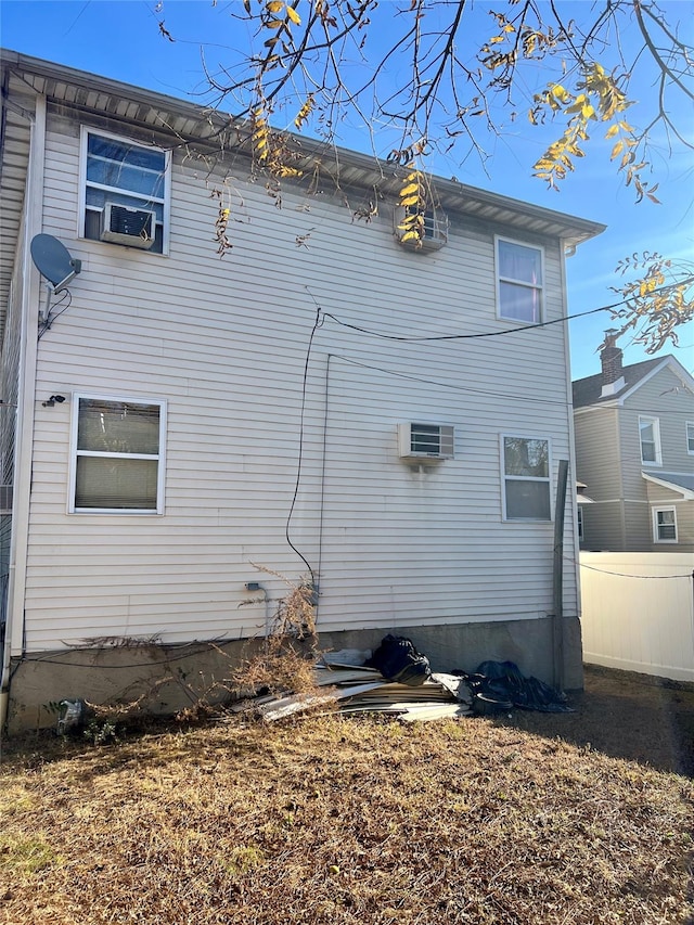 rear view of house featuring a wall mounted AC