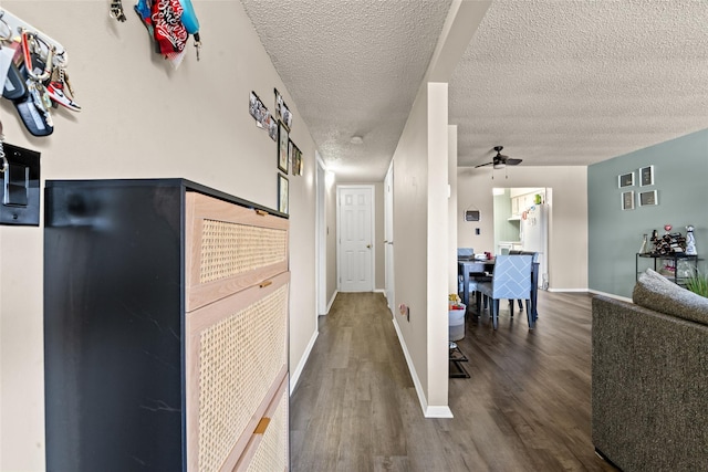 hall with a textured ceiling and dark hardwood / wood-style floors