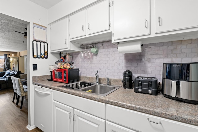 kitchen featuring ceiling fan, decorative backsplash, white cabinetry, and sink