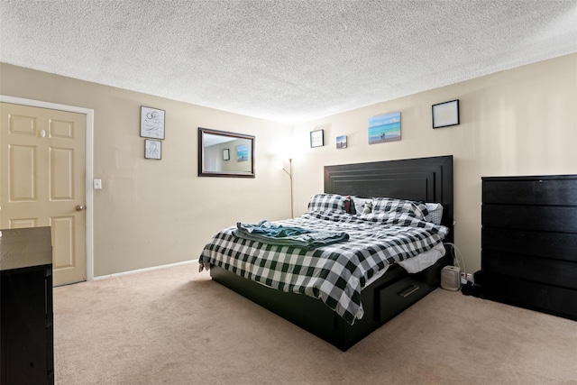 bedroom with light colored carpet and a textured ceiling