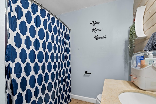 bathroom featuring tile patterned floors, toilet, and wooden walls