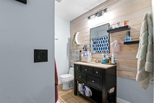 bathroom featuring toilet, vanity, tile patterned floors, and wood walls