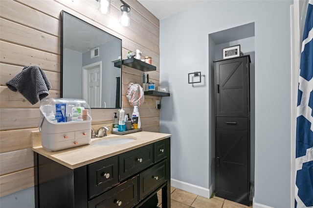 bathroom featuring tile patterned flooring, vanity, and wood walls