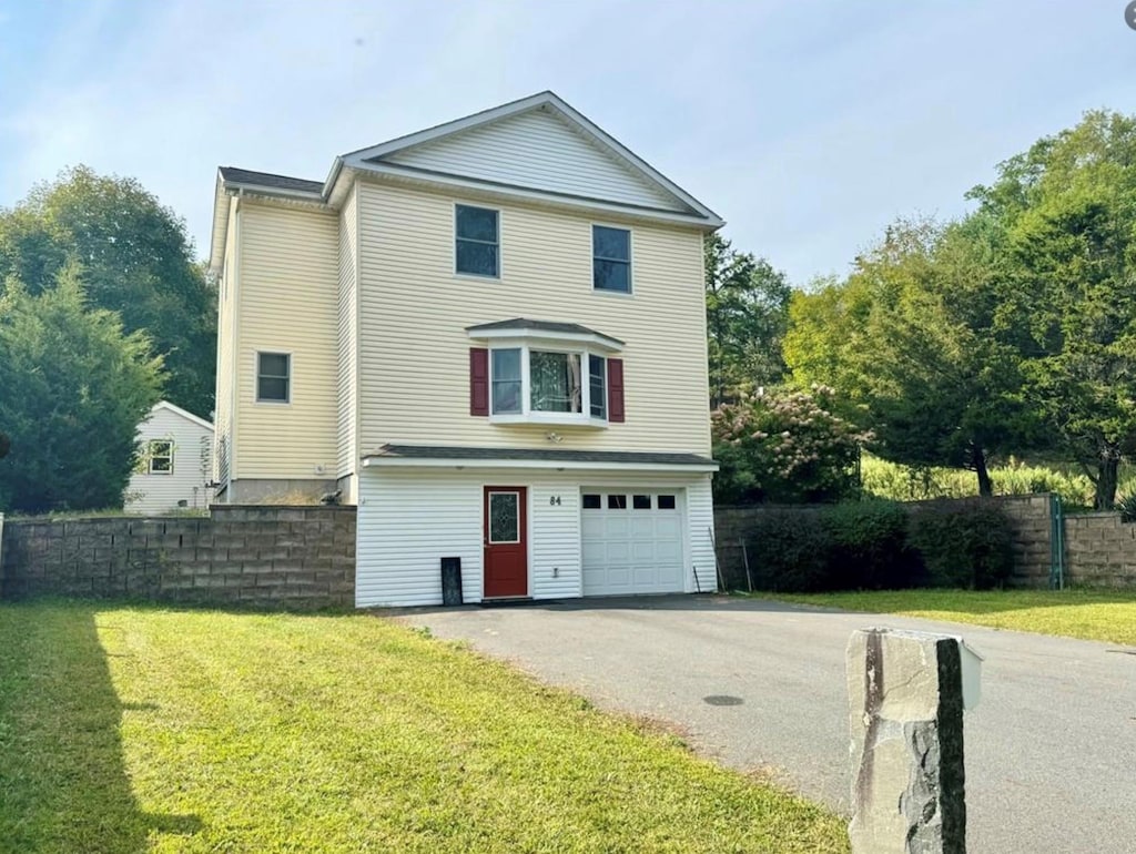 view of front of property featuring a front lawn and a garage