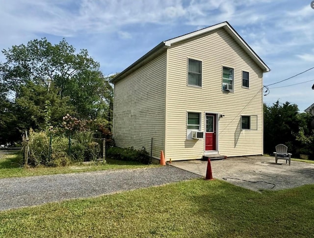 back of house featuring a yard, cooling unit, an outdoor fire pit, and a patio area