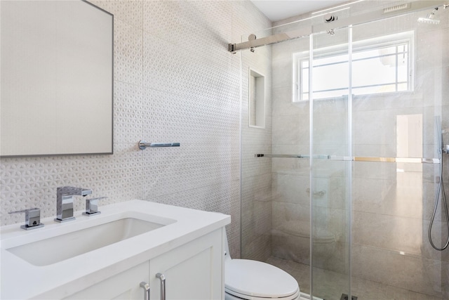 bathroom with vanity, toilet, and a shower with door