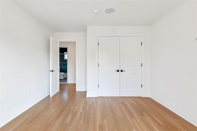 unfurnished bedroom with light hardwood / wood-style flooring and a closet