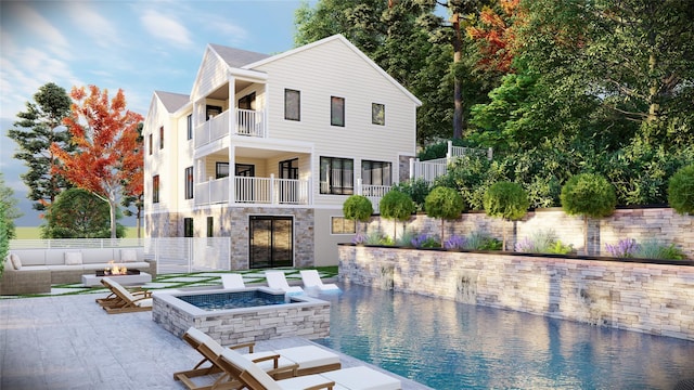 rear view of house featuring stone siding, an outdoor fire pit, fence, and a patio