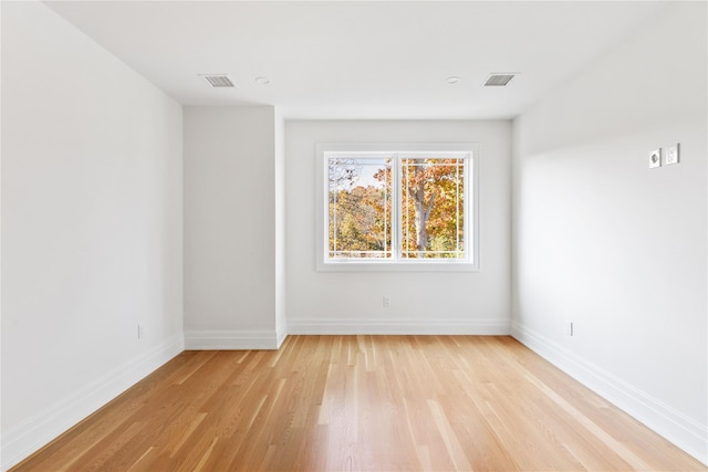 spare room with visible vents, baseboards, and light wood-style floors