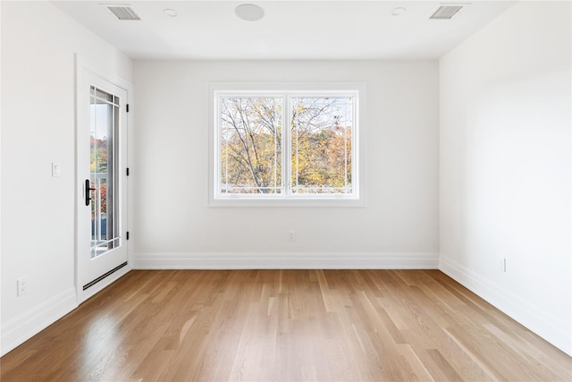 unfurnished room with visible vents, light wood-type flooring, and baseboards