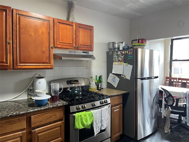 kitchen featuring dark stone countertops, backsplash, and appliances with stainless steel finishes