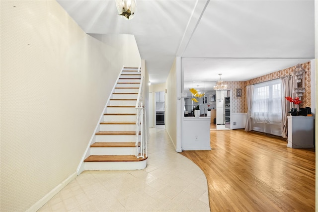 stairs with a notable chandelier