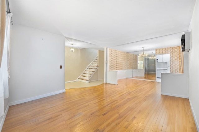 unfurnished living room featuring light hardwood / wood-style floors and a notable chandelier