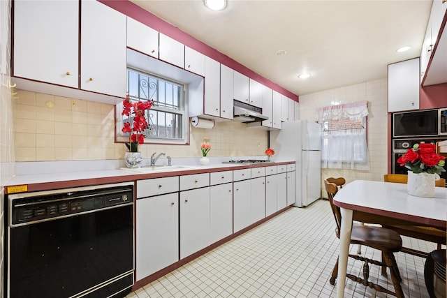 kitchen featuring decorative backsplash, white cabinetry, sink, and black appliances