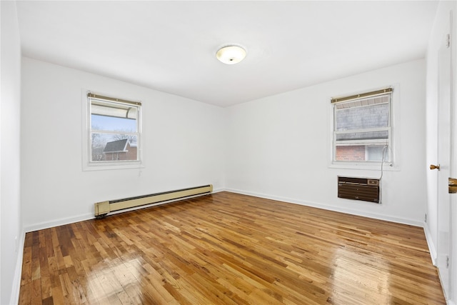 empty room featuring heating unit, a baseboard radiator, and hardwood / wood-style flooring