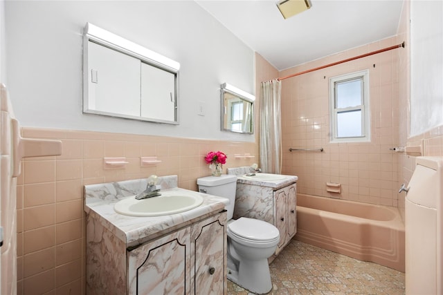 full bathroom with shower / bath combination with curtain, vanity, toilet, and tile walls