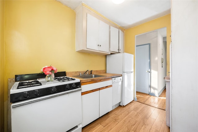 kitchen featuring sink, white cabinets, light hardwood / wood-style floors, and white appliances