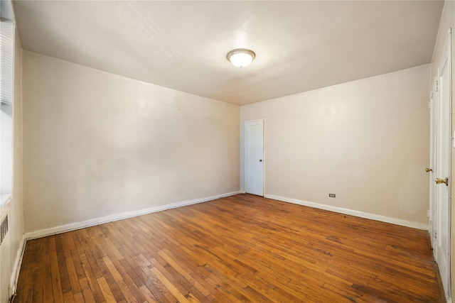 empty room with radiator and hardwood / wood-style flooring