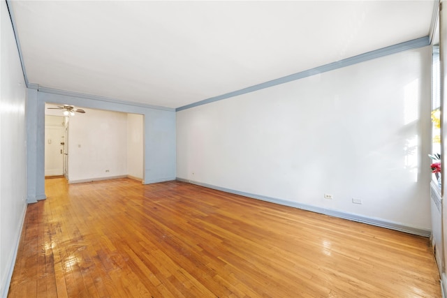 empty room featuring light hardwood / wood-style flooring, ceiling fan, and crown molding