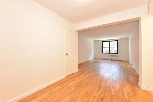 unfurnished room with light wood-type flooring and radiator