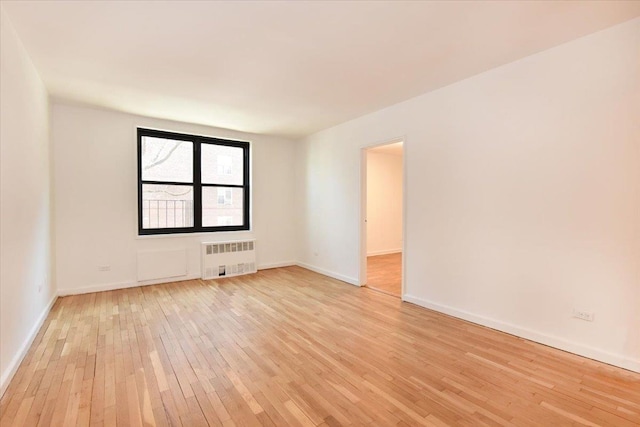 unfurnished room featuring light wood-type flooring and radiator