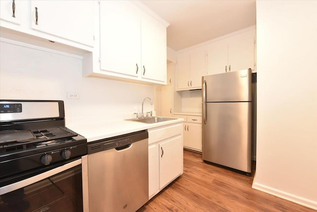 kitchen featuring white cabinetry, sink, light hardwood / wood-style flooring, and appliances with stainless steel finishes