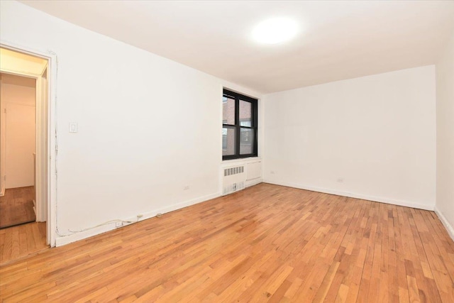 empty room featuring light hardwood / wood-style floors and radiator