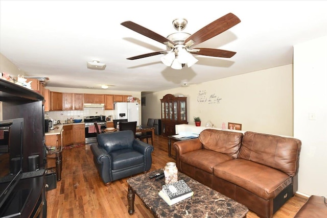 living room featuring ceiling fan and dark hardwood / wood-style floors