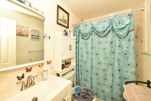 bathroom with toilet, curtained shower, and vanity