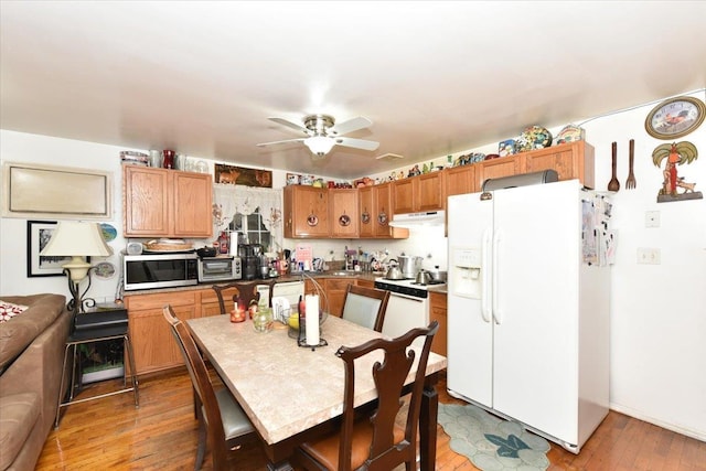 kitchen featuring white appliances, hardwood / wood-style flooring, and ceiling fan