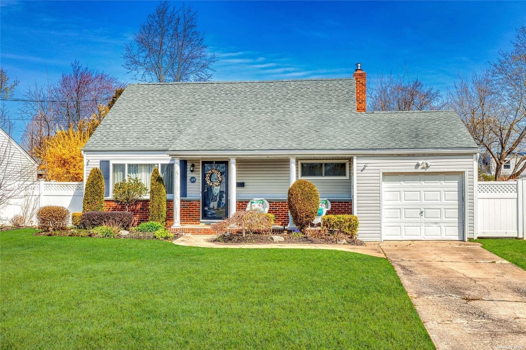 new england style home featuring a front yard and a garage