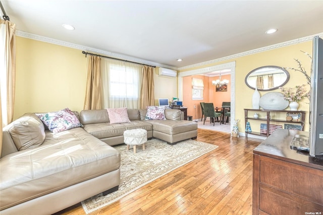 living room with a wall mounted AC, hardwood / wood-style flooring, crown molding, and an inviting chandelier