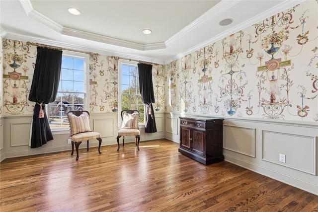 living area with a wealth of natural light, ornamental molding, and hardwood / wood-style flooring