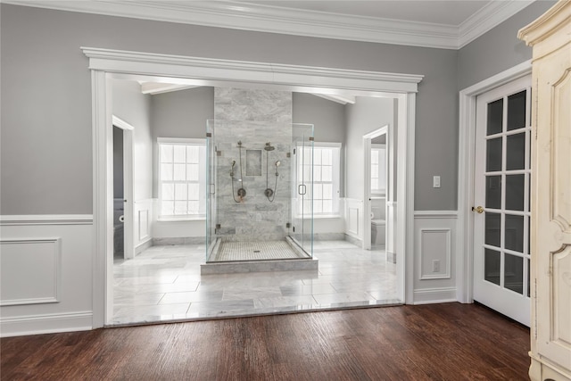 bathroom featuring hardwood / wood-style flooring, toilet, walk in shower, and ornamental molding