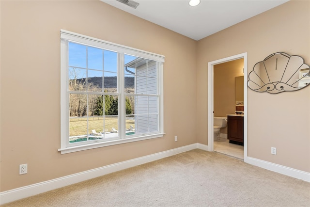 unfurnished room with a mountain view and light colored carpet