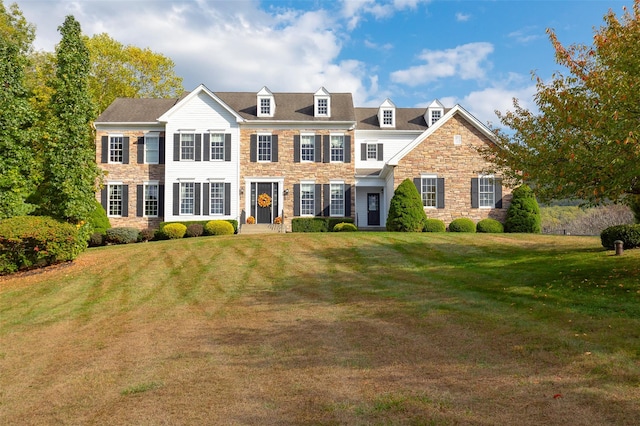 colonial-style house featuring a front lawn