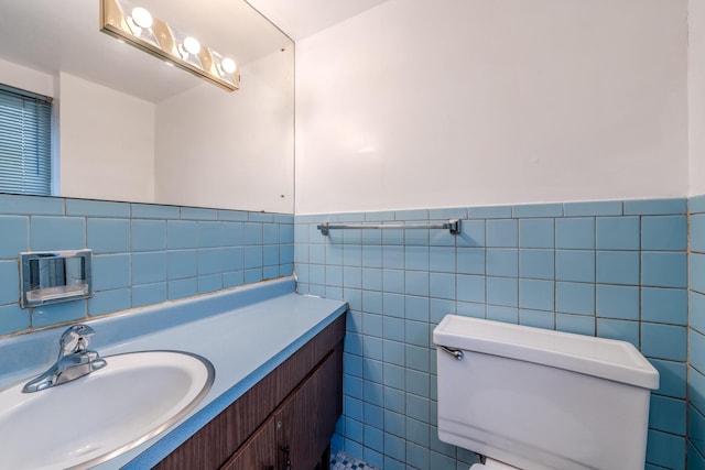 bathroom featuring vanity, toilet, and tile walls