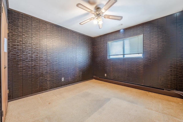 carpeted spare room with wooden walls, ceiling fan, and a baseboard heating unit