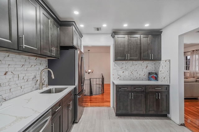 kitchen featuring backsplash, sink, light hardwood / wood-style flooring, stainless steel dishwasher, and dark brown cabinets