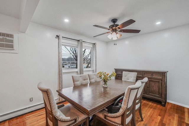 dining space with ceiling fan, light hardwood / wood-style flooring, a wall mounted air conditioner, and a baseboard heating unit