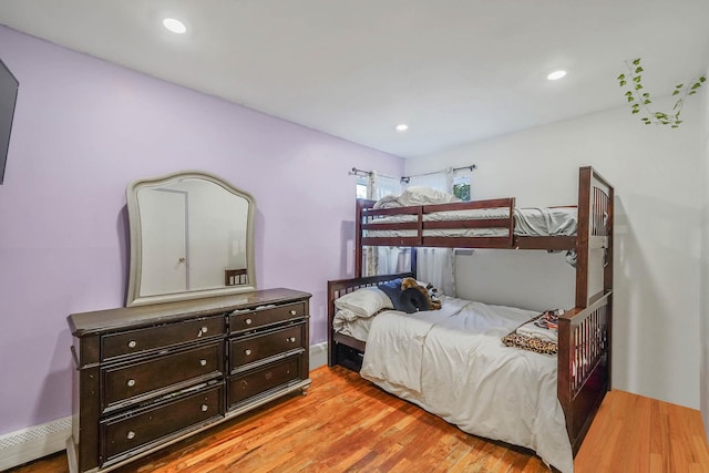 bedroom with light hardwood / wood-style floors and baseboard heating