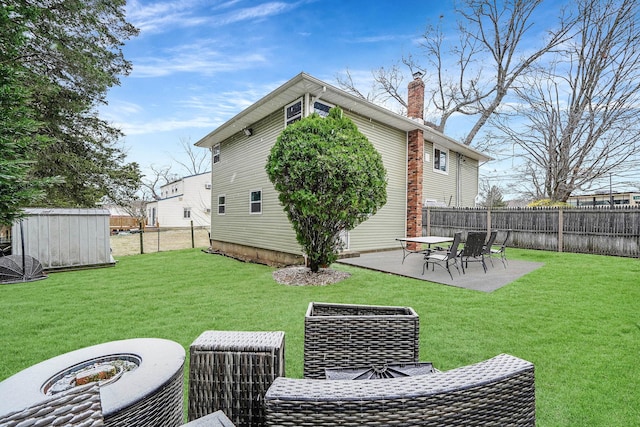 back of property with a patio area, a yard, and a storage unit