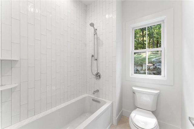 bathroom featuring tiled shower / bath and toilet