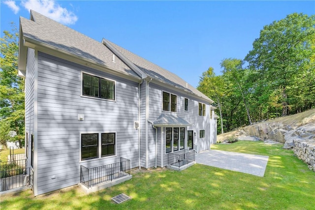 rear view of house featuring a patio area and a yard