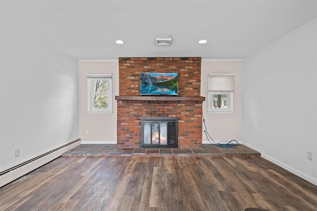 unfurnished living room featuring ornamental molding, a brick fireplace, baseboard heating, and a healthy amount of sunlight